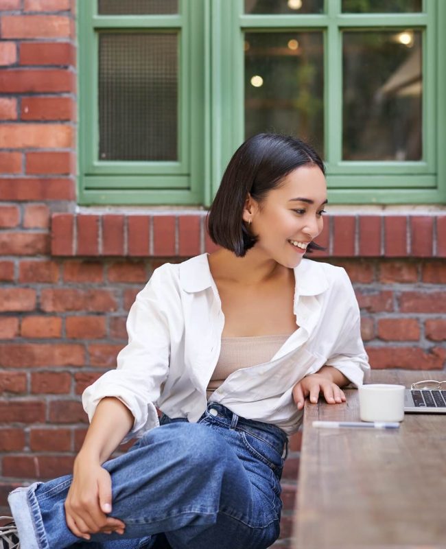 portrait-of-young-stylish-woman-influencer-sitting-in-cafe-with-cup-of-coffee-and-laptop-smiling.jpg
